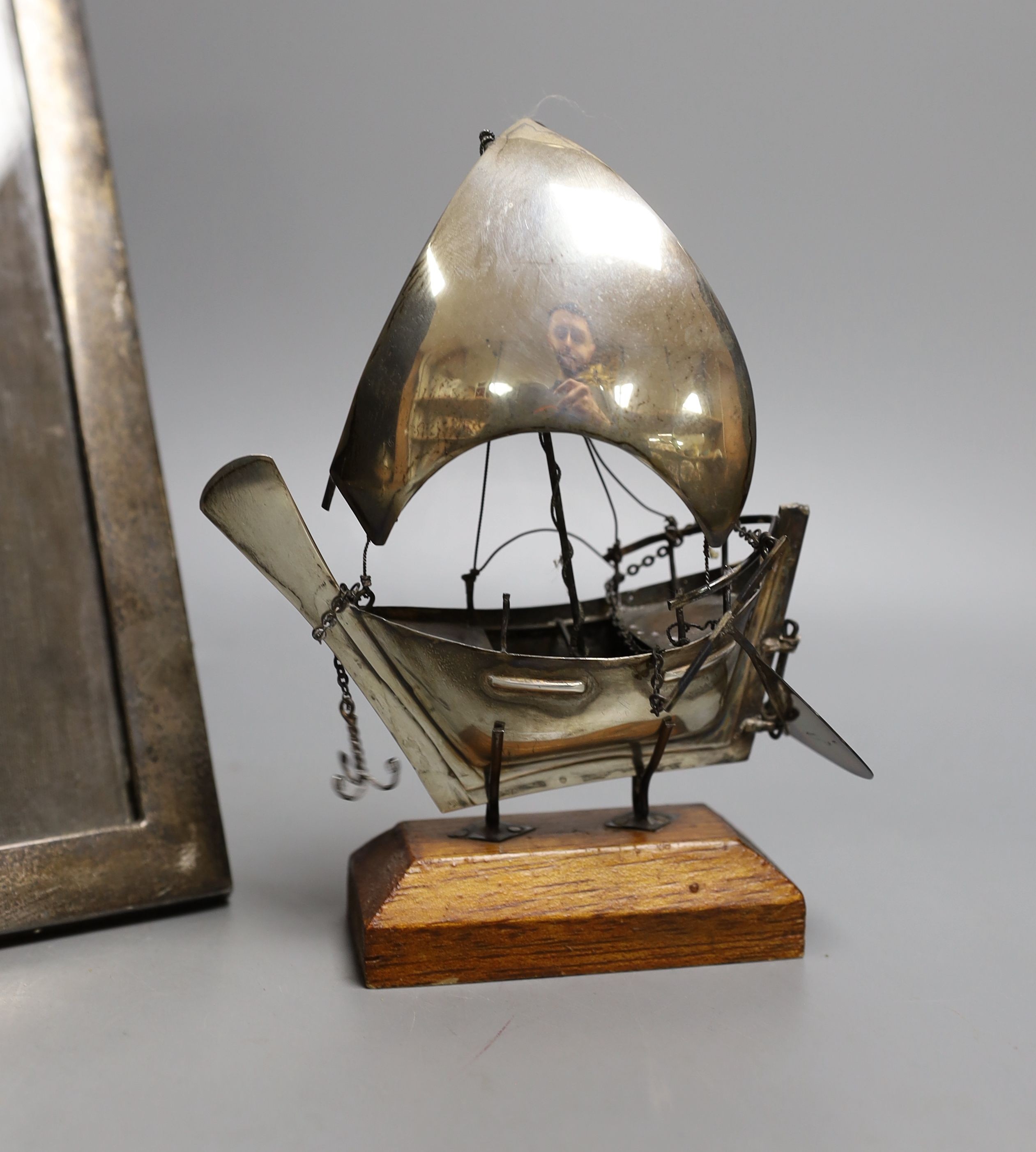 A George V silver mounted rectangular photograph frame, 24.2cm, a 1930's silver trinket box and a miniature white metal model of a sail boat, on wooden stand.